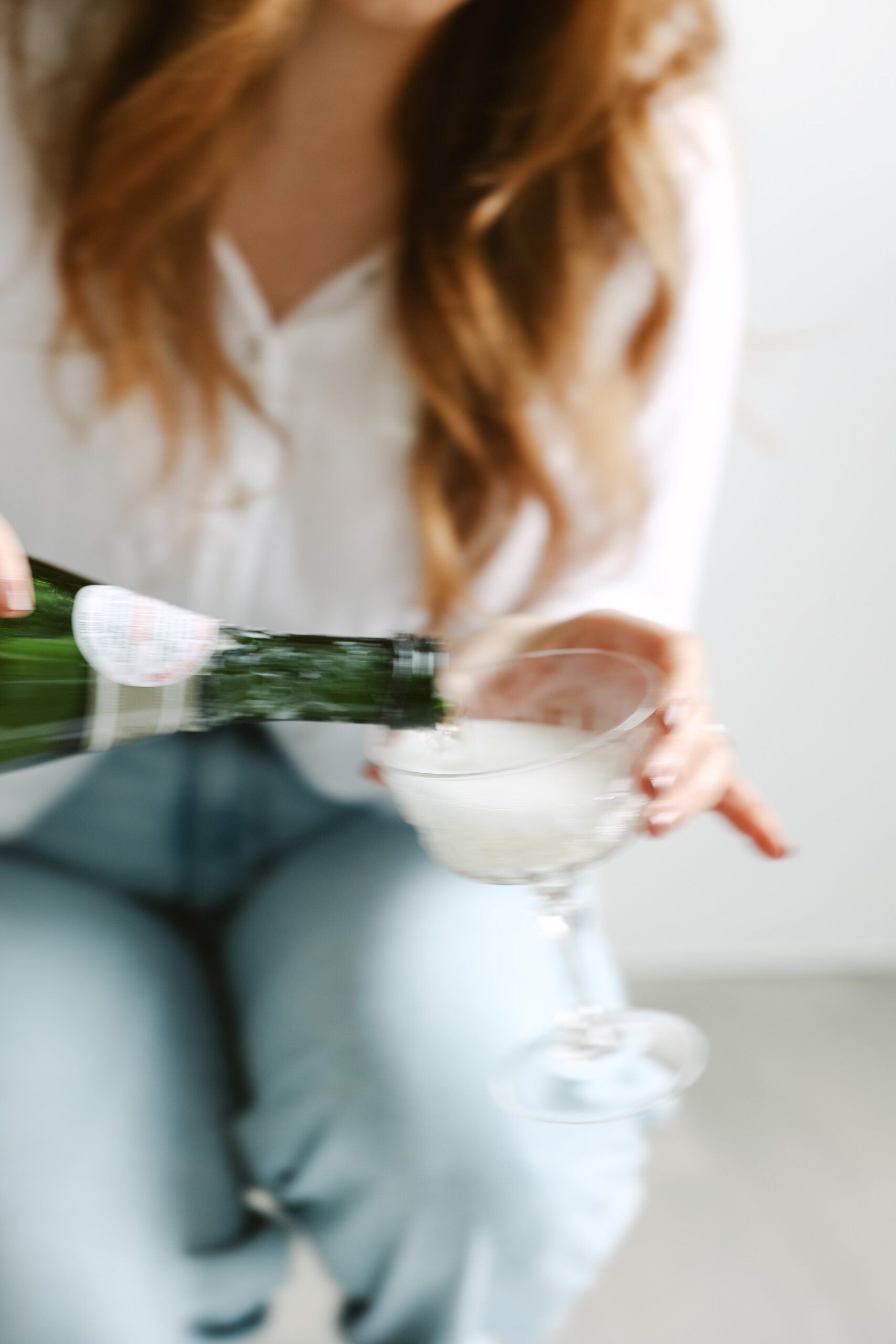 Pouring champagne into glass representing financial wins and stress free bookkeeping for creative entrepreneurs